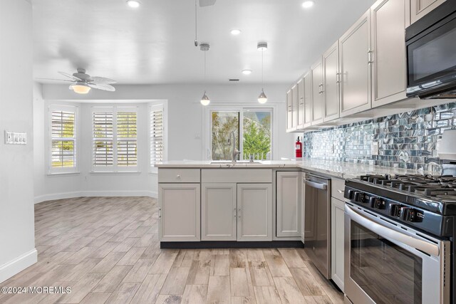 kitchen featuring stainless steel gas range, light hardwood / wood-style floors, plenty of natural light, and sink