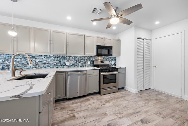 kitchen featuring pendant lighting, gray cabinets, sink, and appliances with stainless steel finishes