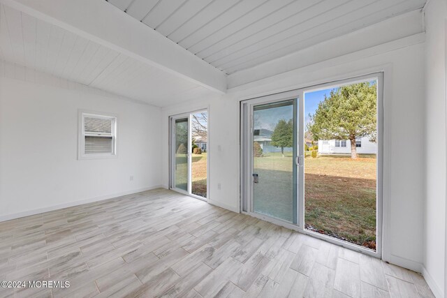 unfurnished room featuring beam ceiling and light hardwood / wood-style floors