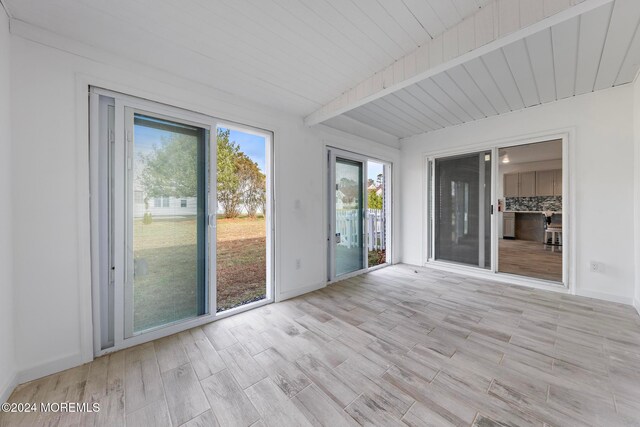 unfurnished sunroom with beam ceiling and wood ceiling