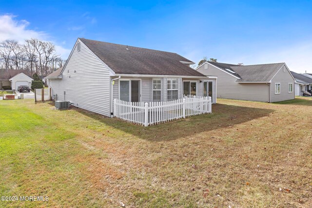 back of property with a yard and central AC unit