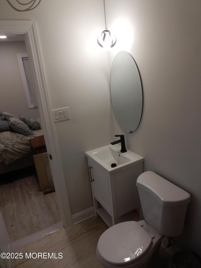 bathroom with vanity, toilet, and hardwood / wood-style floors