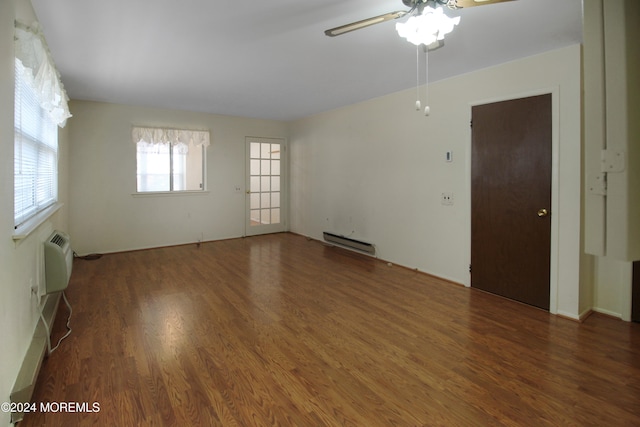 spare room featuring a wall mounted air conditioner, a baseboard radiator, ceiling fan, and dark wood-type flooring