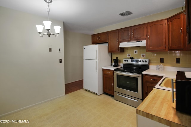 kitchen with stainless steel electric range, white refrigerator, hanging light fixtures, decorative backsplash, and a notable chandelier