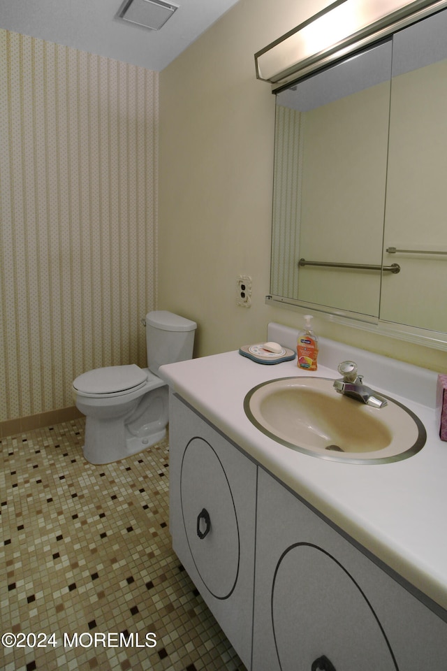 bathroom with tile patterned flooring, vanity, and toilet