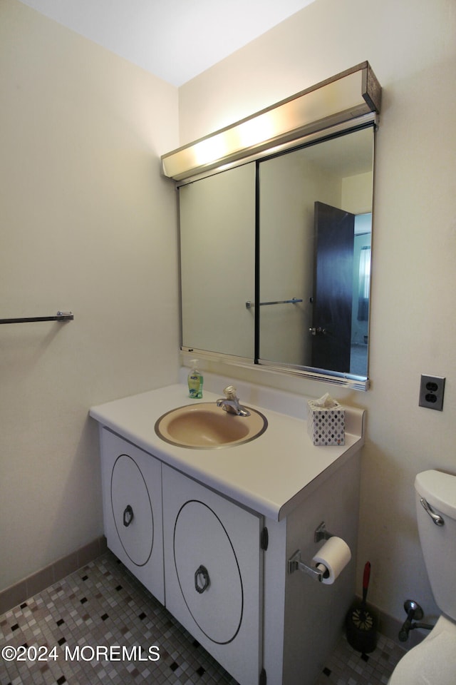 bathroom featuring tile patterned flooring, vanity, and toilet