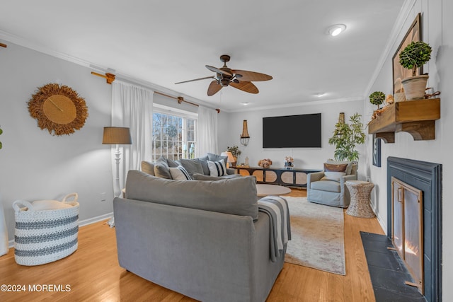 living room featuring ceiling fan, ornamental molding, and hardwood / wood-style flooring