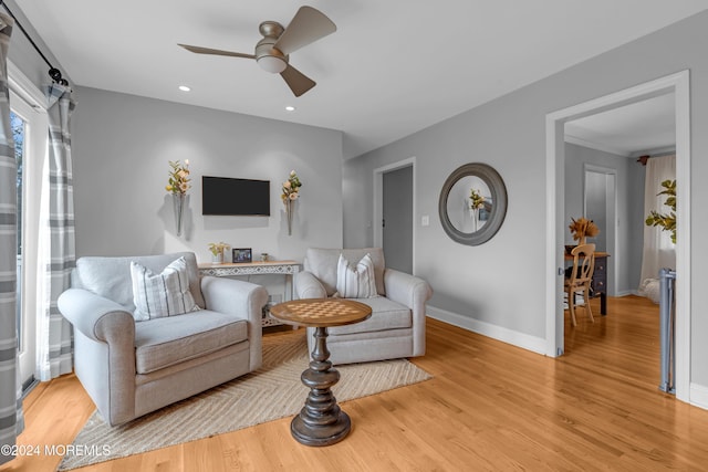 living room featuring light wood-type flooring and ceiling fan