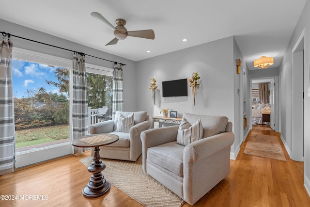 living room featuring ceiling fan, a healthy amount of sunlight, and light wood-type flooring