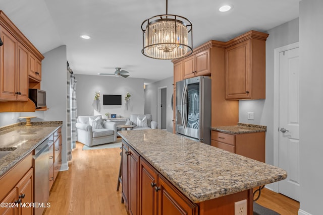 kitchen featuring a center island, a kitchen bar, light wood-type flooring, and appliances with stainless steel finishes