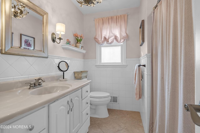 bathroom with a shower with curtain, vanity, tile walls, tile patterned flooring, and toilet