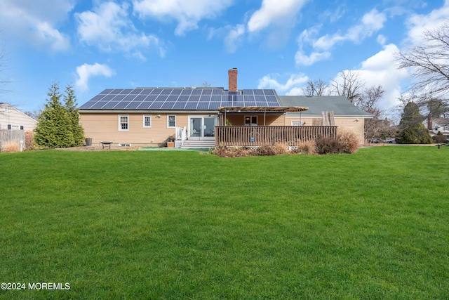 back of house featuring solar panels and a yard