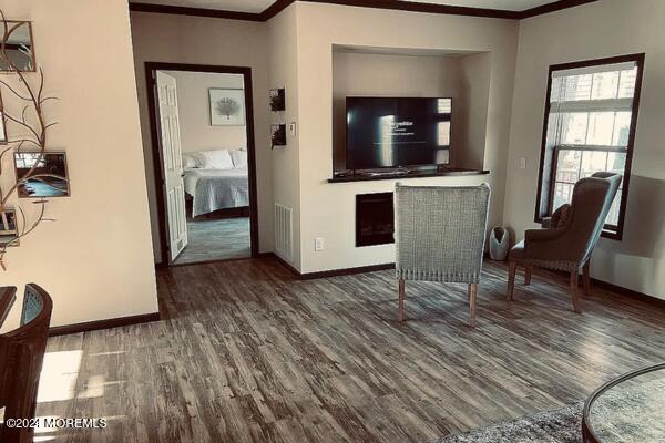 interior space featuring crown molding and dark wood-type flooring