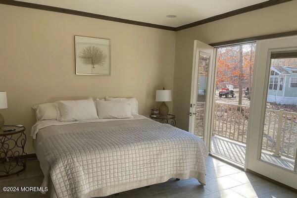 bedroom with access to outside and ornamental molding