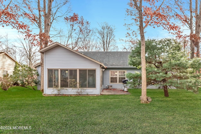 rear view of house featuring a yard