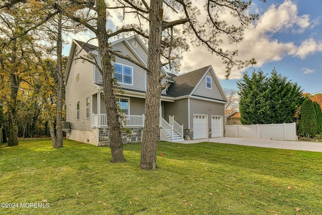 front of property featuring a front lawn, covered porch, and a garage