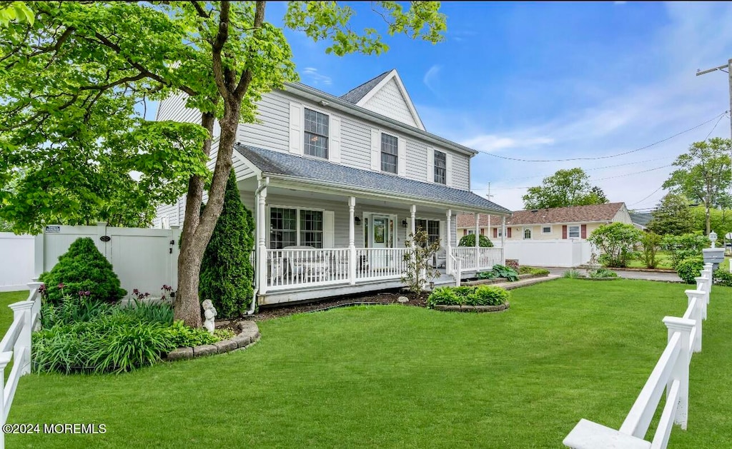 view of front of property with covered porch and a front yard