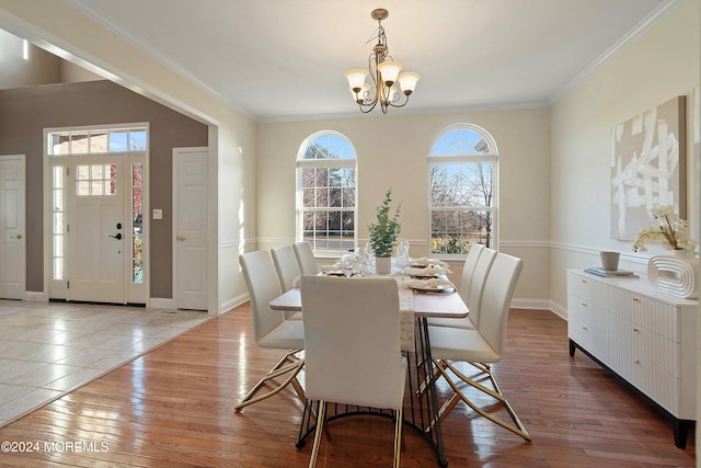 dining room with a chandelier, wood-type flooring, and ornamental molding