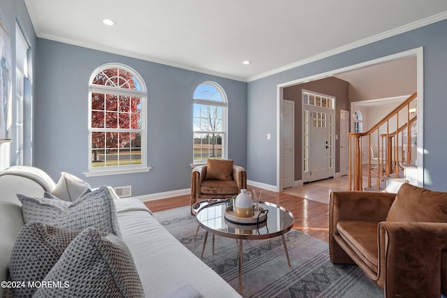 living room with light wood-type flooring and ornamental molding