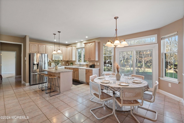 dining room featuring light tile patterned floors, an inviting chandelier, and sink