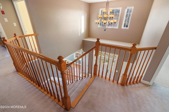 stairs with carpet and a chandelier