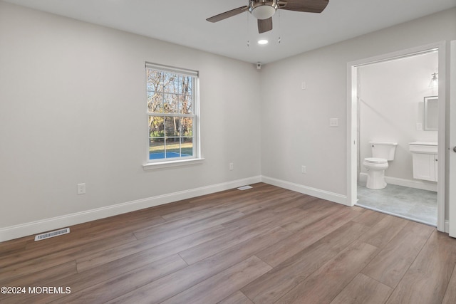 unfurnished bedroom with ceiling fan, ensuite bathroom, and light hardwood / wood-style floors