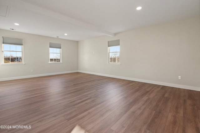 unfurnished room featuring beamed ceiling and hardwood / wood-style floors