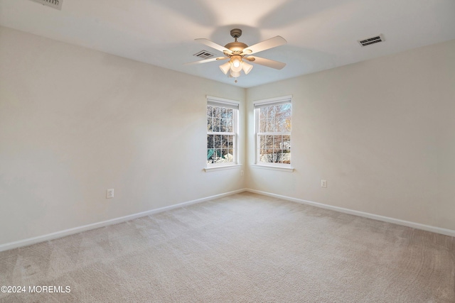 carpeted spare room featuring ceiling fan