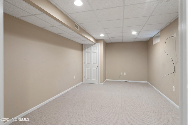 basement featuring a drop ceiling and carpet floors