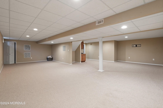 basement featuring a paneled ceiling and light carpet