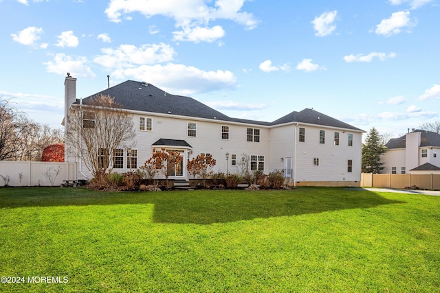 rear view of house featuring a yard