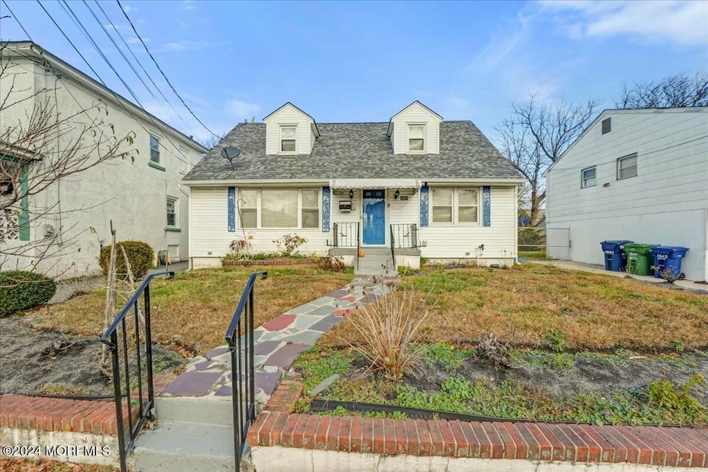 cape cod house featuring a front lawn