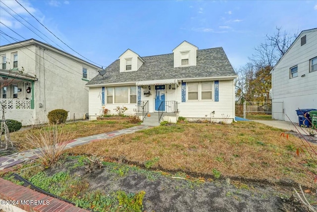 cape cod home featuring a front lawn