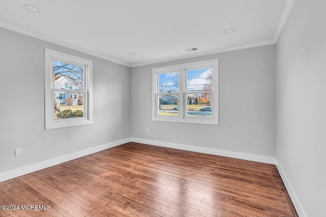 empty room with wood-type flooring and ornamental molding