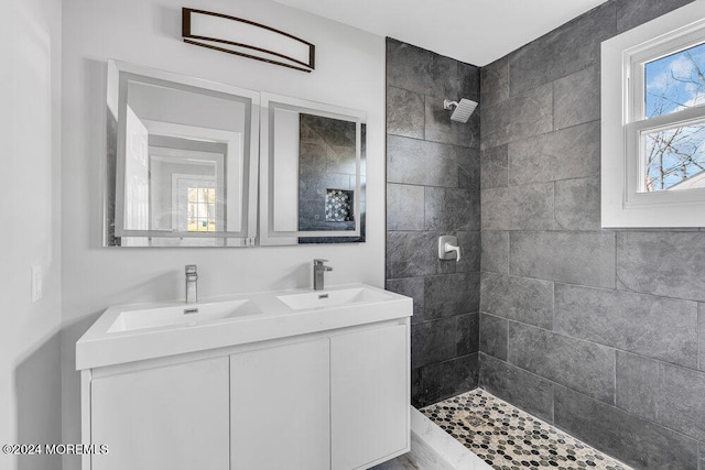 bathroom with a tile shower and vanity