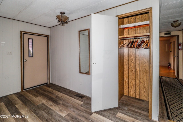 foyer with dark hardwood / wood-style floors and wooden walls