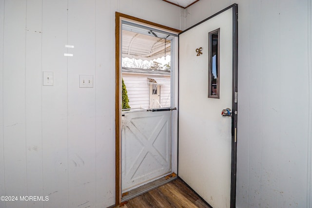 entryway with dark hardwood / wood-style flooring and wooden walls