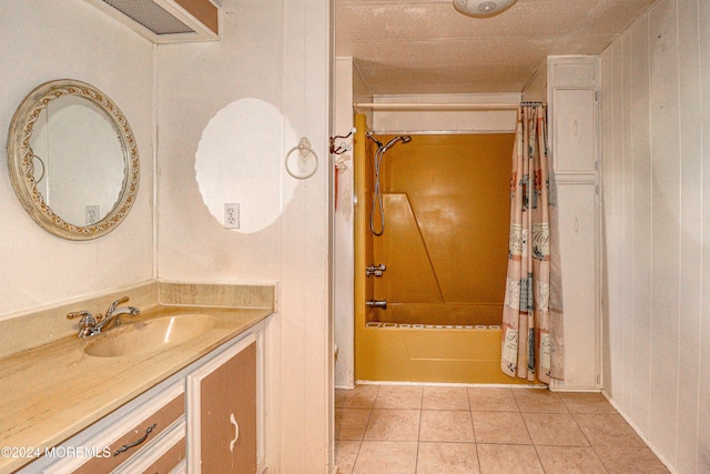 bathroom featuring shower / bath combo, vanity, tile patterned floors, and wooden walls