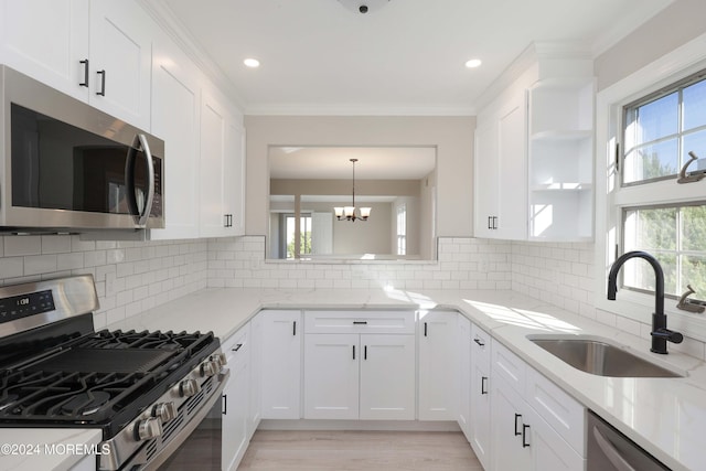 kitchen featuring backsplash, sink, white cabinets, and appliances with stainless steel finishes