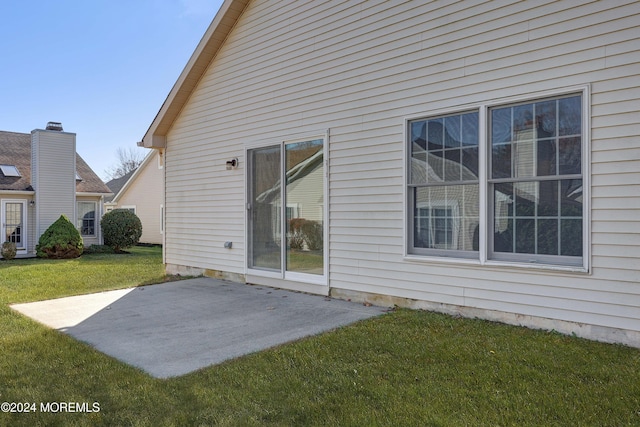 back of house featuring a lawn and a patio