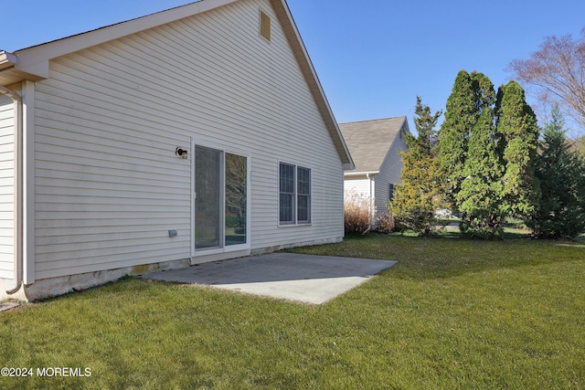 back of house with a lawn and a patio area