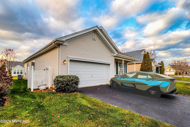 view of side of home with a yard and a garage