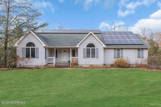 ranch-style house featuring solar panels, a porch, and a front lawn