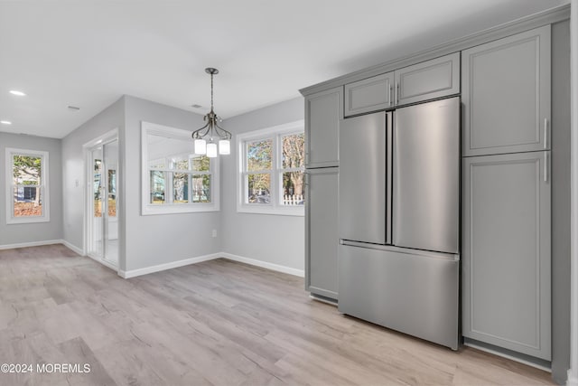 kitchen featuring gray cabinetry, a wealth of natural light, light hardwood / wood-style floors, and stainless steel refrigerator