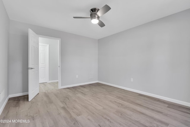 empty room with ceiling fan and light hardwood / wood-style flooring