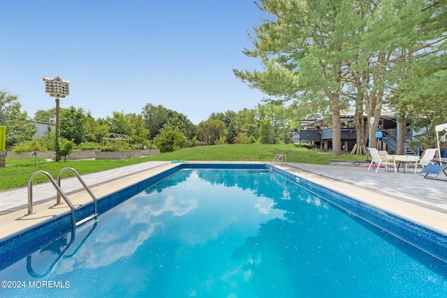 view of swimming pool featuring a yard and a patio