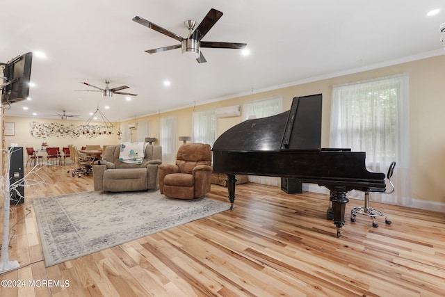 interior space featuring a wall mounted air conditioner, ceiling fan, light wood-type flooring, and crown molding