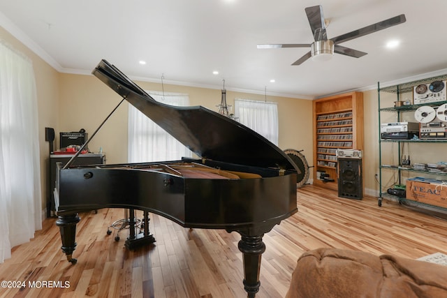 misc room with light hardwood / wood-style floors, ceiling fan, and crown molding