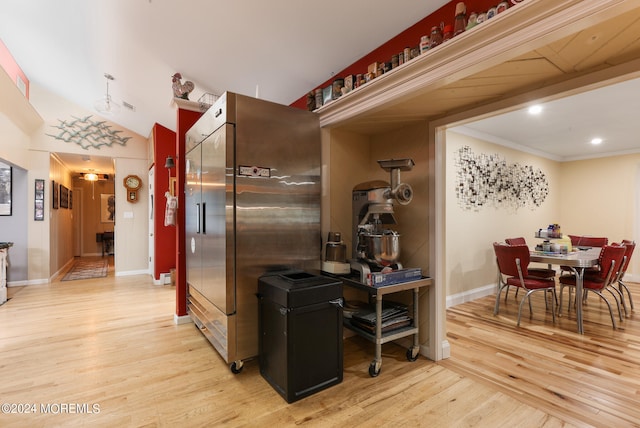 kitchen featuring light wood-type flooring, crown molding, and high end refrigerator