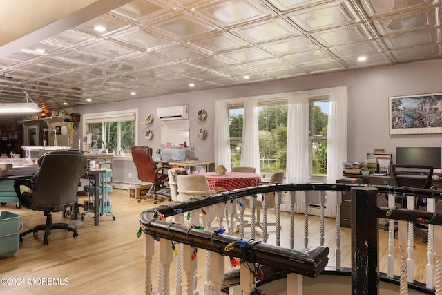 game room featuring light hardwood / wood-style floors and a wall unit AC